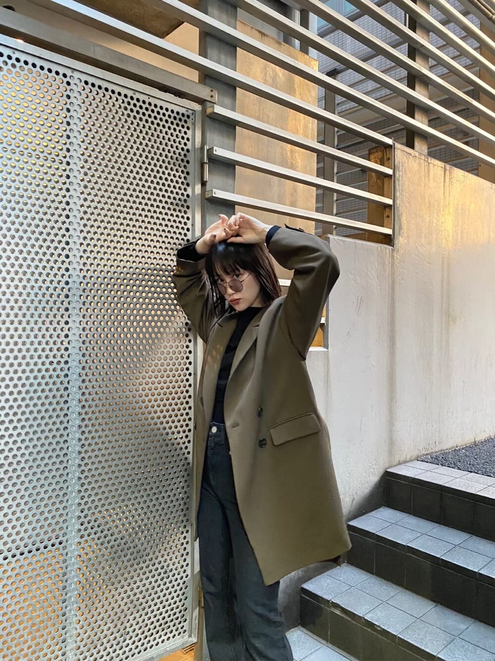 ベージュ系のテーラードジャケット、ブラウン系のパンプス、ブラック系のデニムパンツを着用したレディースの秋コーディネートの2枚目の写真