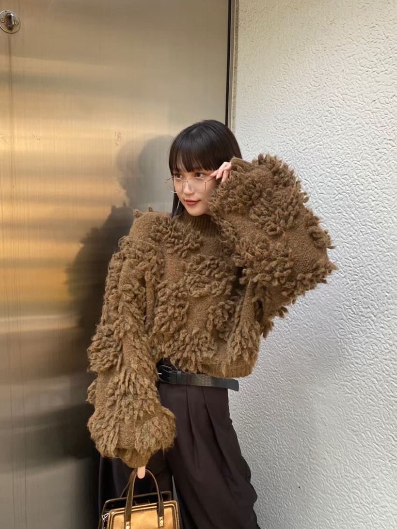 ブラック系のスラックス、ブラック系のパンプス、ブラウン系のハンドバッグを着用したレディースの秋コーディネートの2枚目の写真