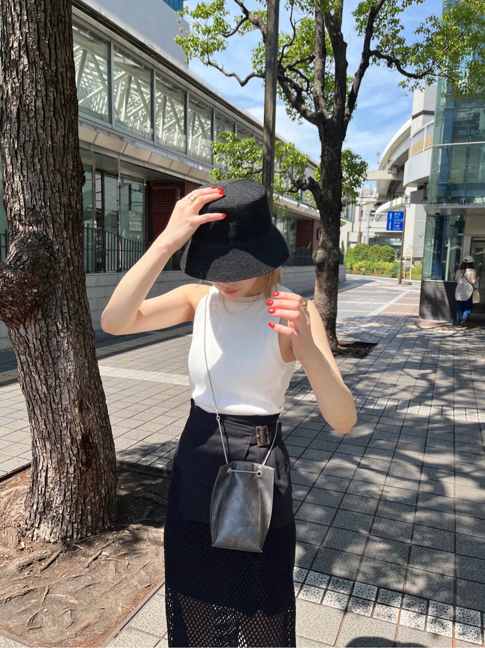 ホワイト系のサンダル、ブラック系のスカート、ホワイト系のタンクトップを着用したレディースの夏コーディネートの4枚目の写真