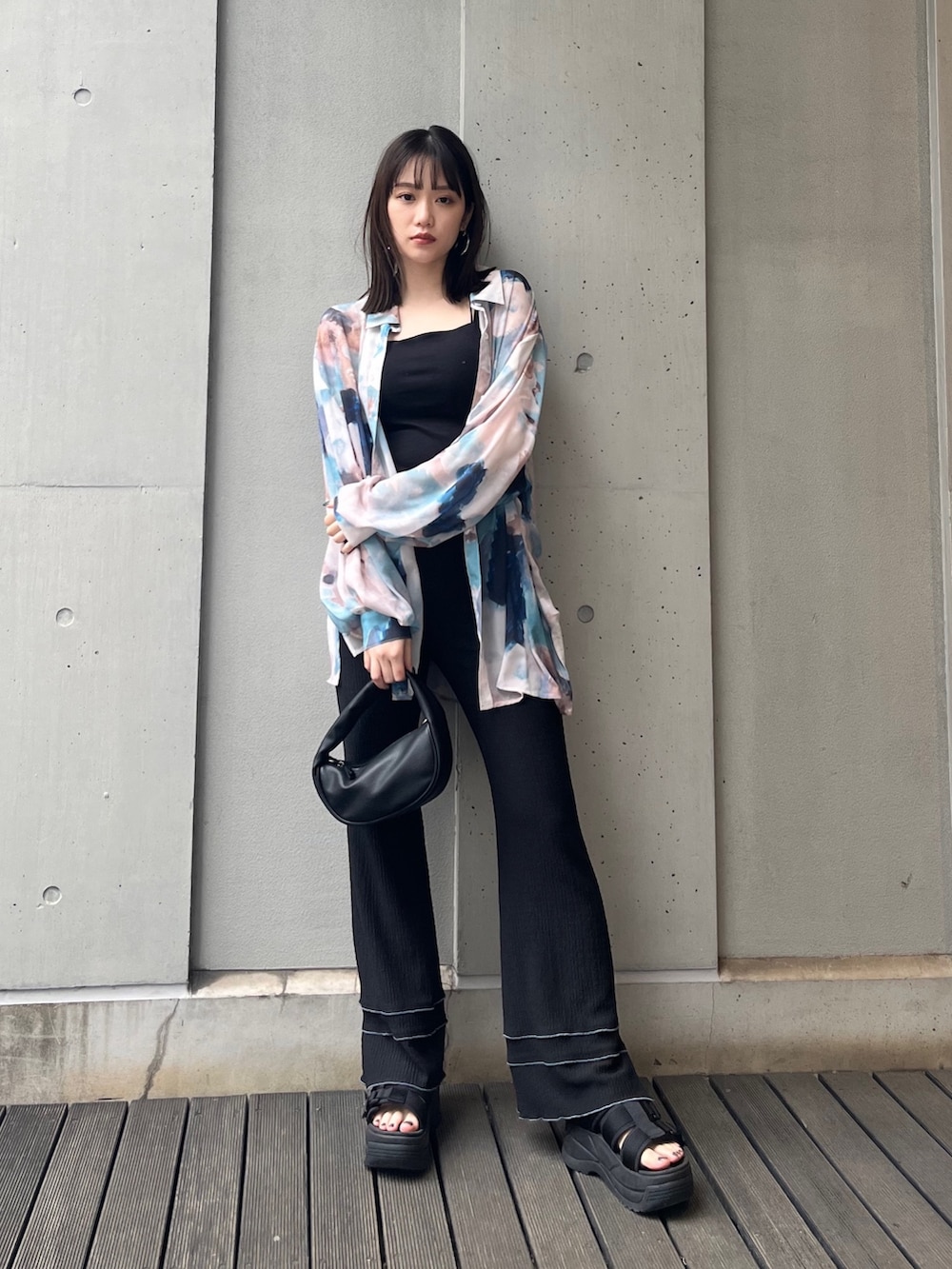 ブラック系のハンドバッグ、ブラック系のサンダル、ブルー系のシャツ/ブラウスを着用したレディースの冬コーディネートの2枚目の写真