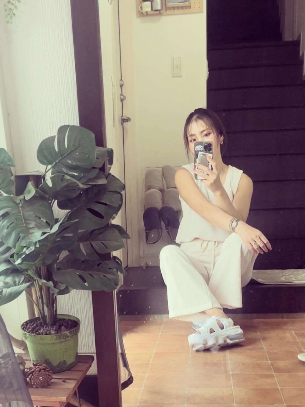 ホワイト系のタンクトップ、ホワイト系のパンツ、ホワイト系のサンダルを着用したレディースの夏コーディネートの2枚目の写真