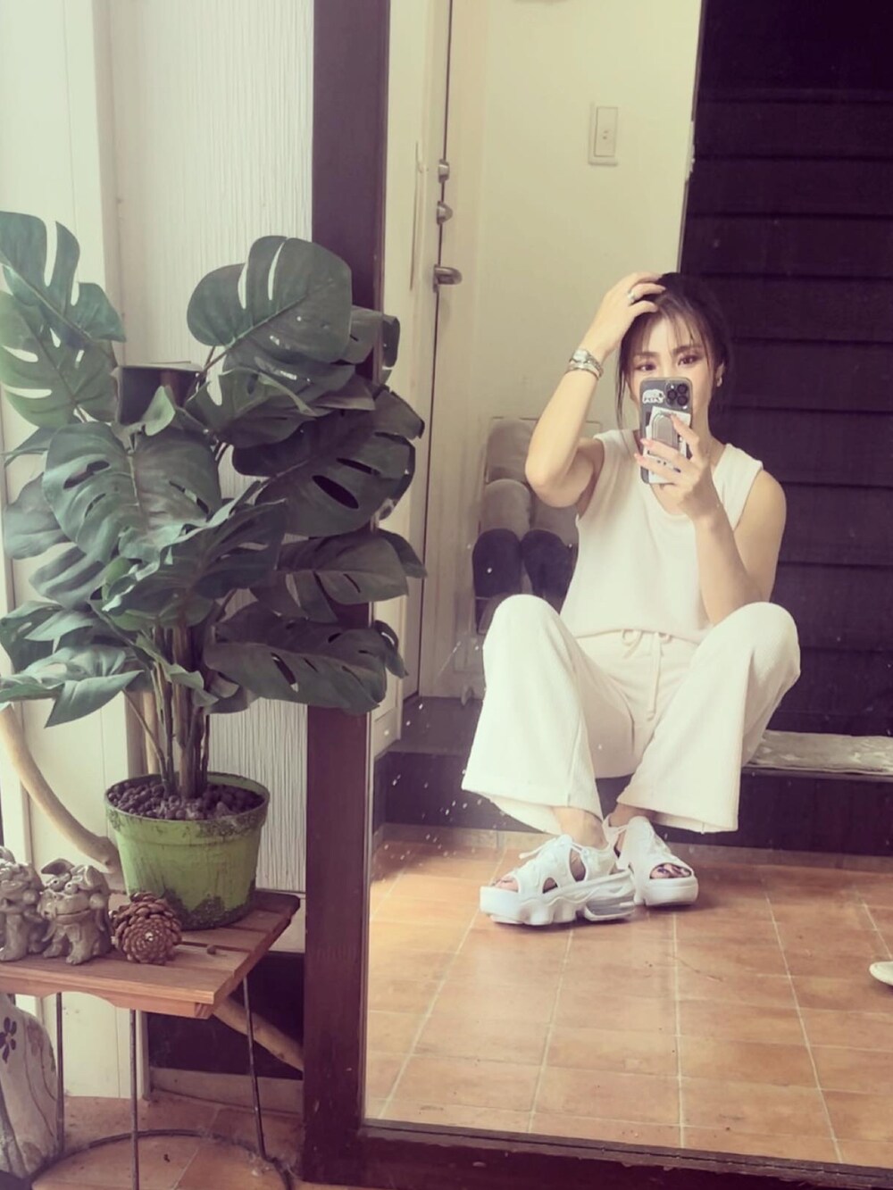 ホワイト系のタンクトップ、ホワイト系のパンツ、ホワイト系のサンダルを着用したレディースの夏コーディネートの3枚目の写真