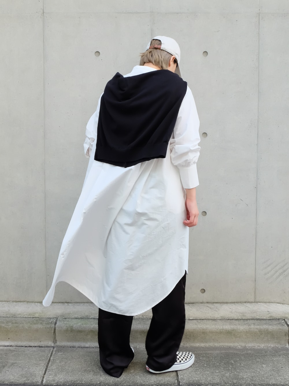 ホワイト系のシャツワンピース、ブラック系のその他パンツ、その他のスリッポンを着用したレディースの秋コーディネートの3枚目の写真