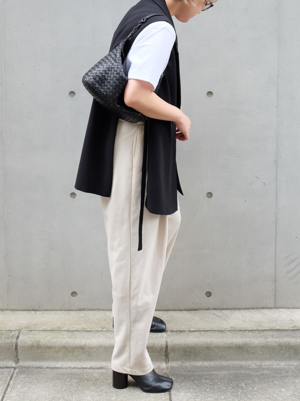 ブラック系のブーツ、ホワイト系のスウェットパンツ、ブラック系のハンドバッグを着用したレディースの秋コーディネートの2枚目の写真