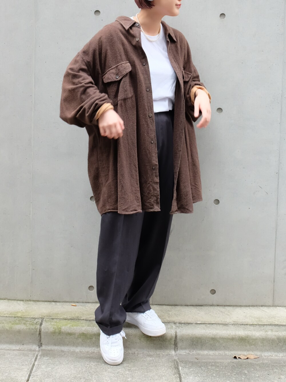 グレー系のスラックス、ホワイト系のスニーカー、ホワイト系のTシャツ/カットソーを着用したレディースの秋コーディネートの2枚目の写真