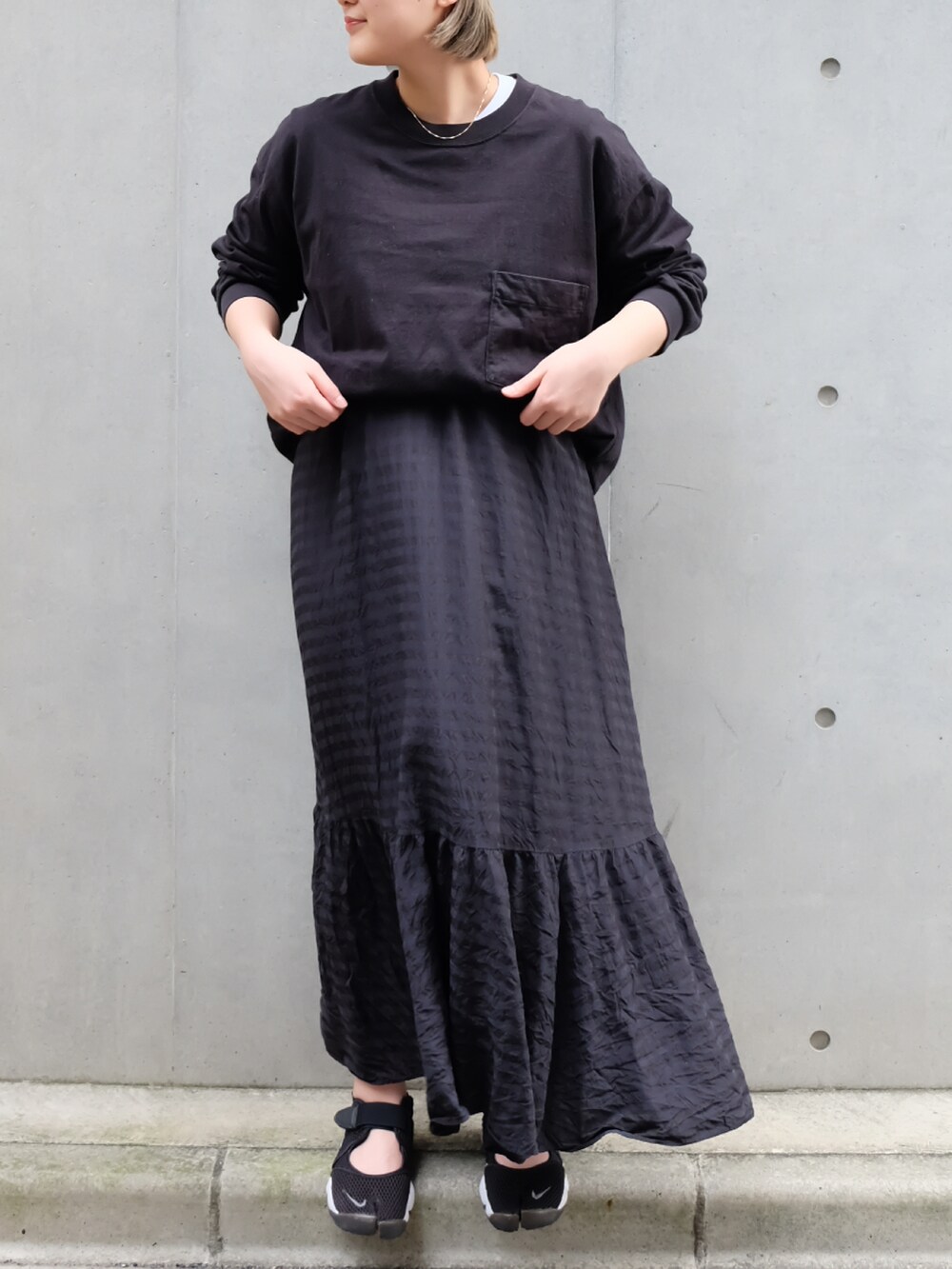 ブラック系のTシャツ/カットソー、ブラック系のワンピース、ブラック系のスニーカーを着用したレディースの秋コーディネートの3枚目の写真