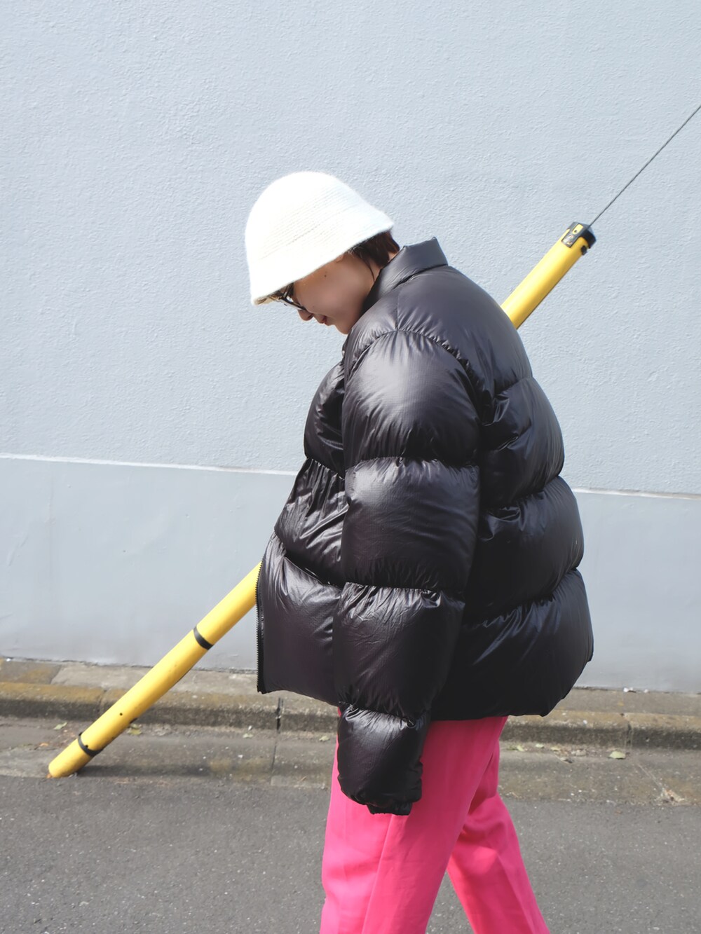 ブラック系のブーツ、ブラック系のダウンジャケット/コート、ピンク系のスラックスを着用したレディースの冬コーディネートの3枚目の写真