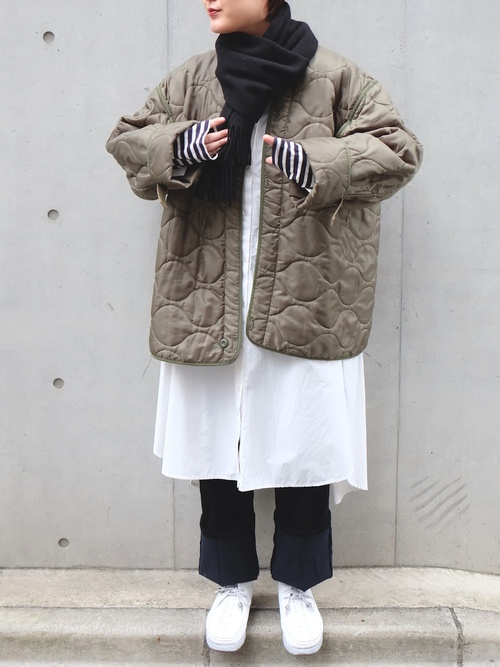 ホワイト系のモカシン/デッキシューズ、グリーン系のジャケット/アウター、ホワイト系のシャツワンピースを着用したレディースの冬コーディネートの2枚目の写真