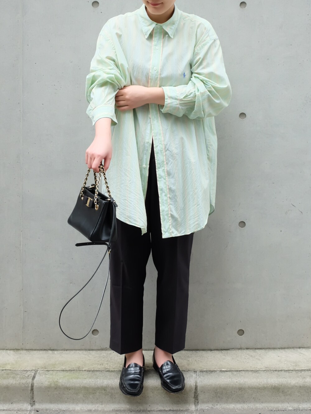 ブラック系のローファー、ブラック系のハンドバッグ、グリーン系のシャツ/ブラウスを着用したレディースの夏コーディネートの2枚目の写真