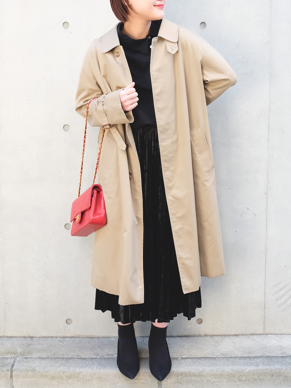 ブラック系のパンプス、ブラック系のスカート、ベージュ系のその他アウターを着用したレディースの冬コーディネートの2枚目の写真