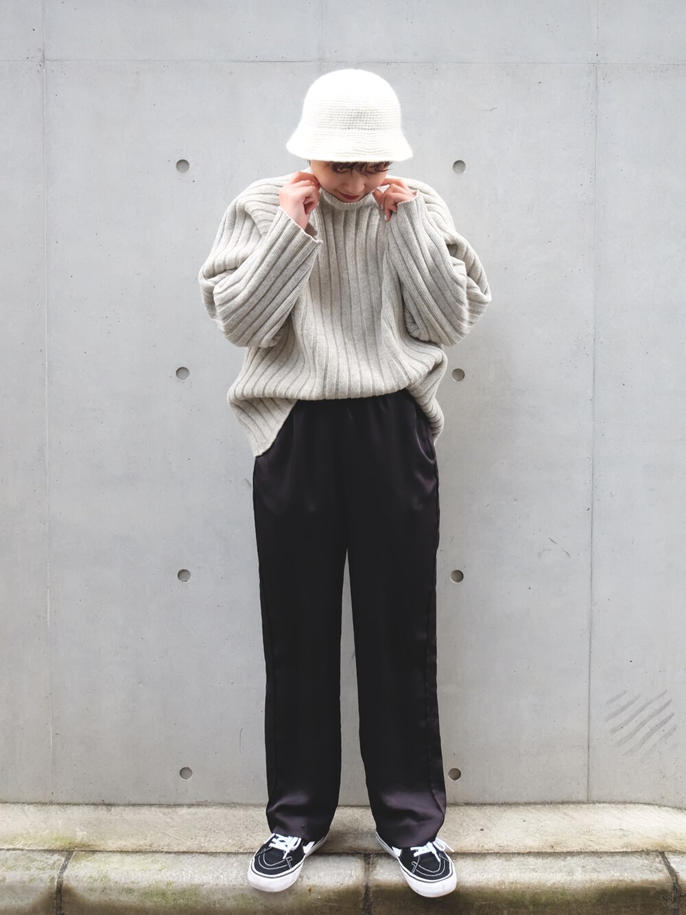 ブラック系のその他パンツ、グレー系のニット/セーター、ブラック系のスニーカーを着用したレディースの冬コーディネートの2枚目の写真