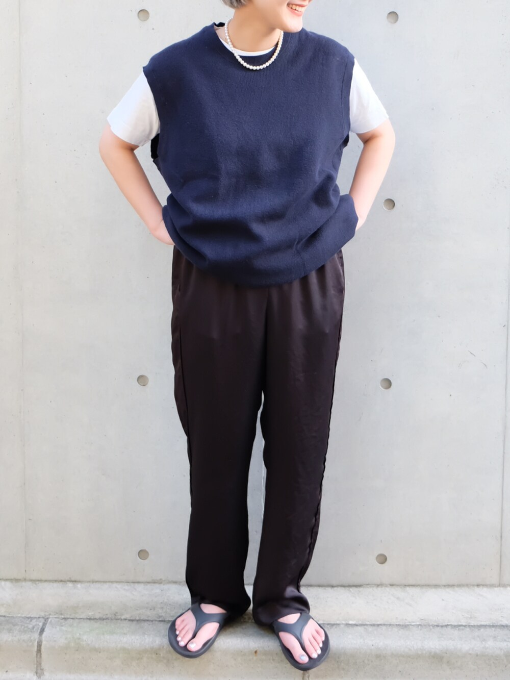 ブラック系のその他パンツ、ブラック系のサンダル、ブルー系のベストを着用したレディースの夏コーディネートの3枚目の写真