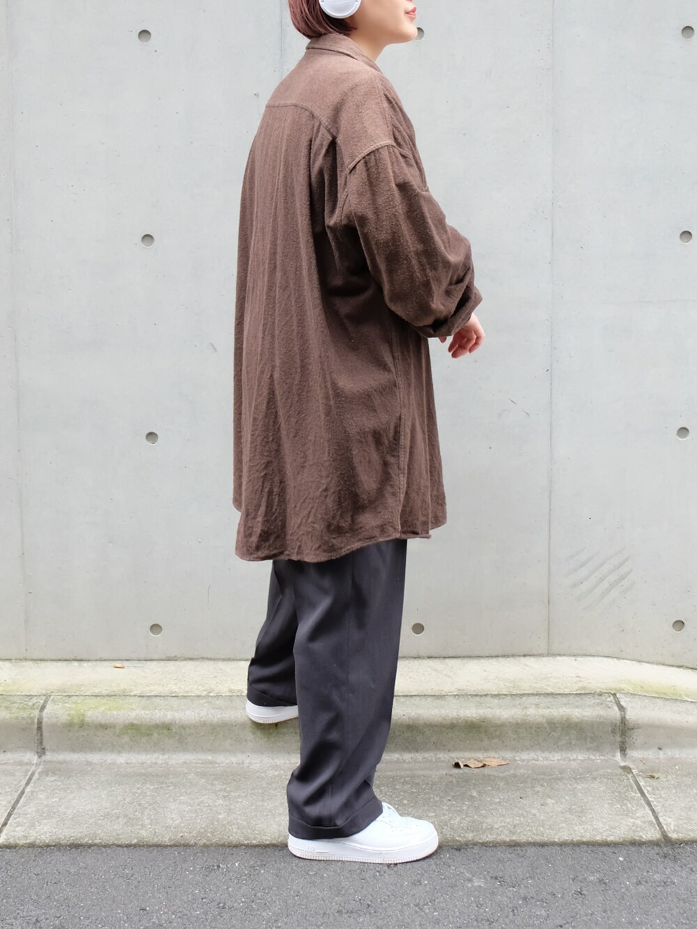 グレー系のスラックス、ホワイト系のスニーカー、ホワイト系のTシャツ/カットソーを着用したレディースの秋コーディネートの3枚目の写真