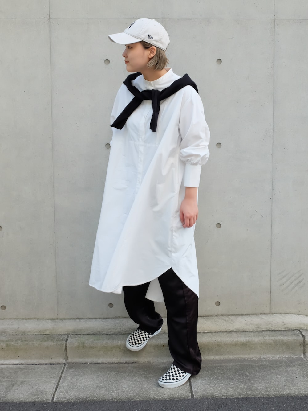 ホワイト系のシャツワンピース、ブラック系のその他パンツ、その他のスリッポンを着用したレディースの秋コーディネートの4枚目の写真