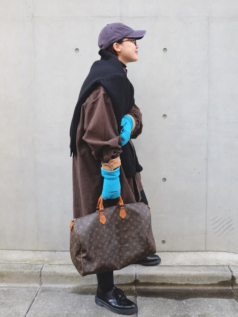 ブラウン系のボストンバッグ、ブラック系のブーツ、ブラック系のニット/セーターを着用したレディースの冬コーディネートの3枚目の写真