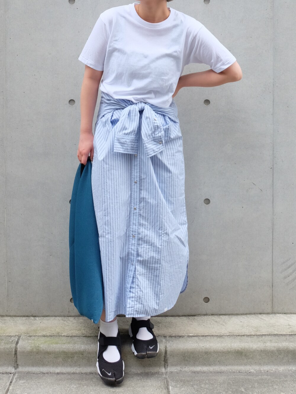 ブルー系のトートバッグ、ホワイト系のTシャツ/カットソー、ブラック系のスニーカーを着用したレディースの夏コーディネートの2枚目の写真