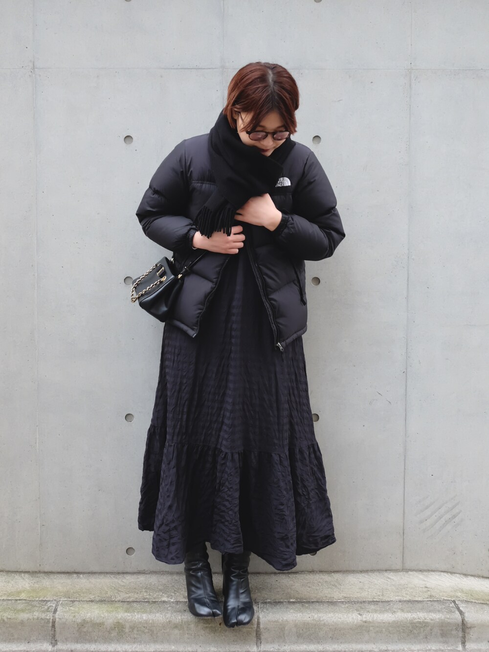ブラック系のブーツ、ブラック系のダウンジャケット/コートを着用したレディースの冬コーディネートの2枚目の写真