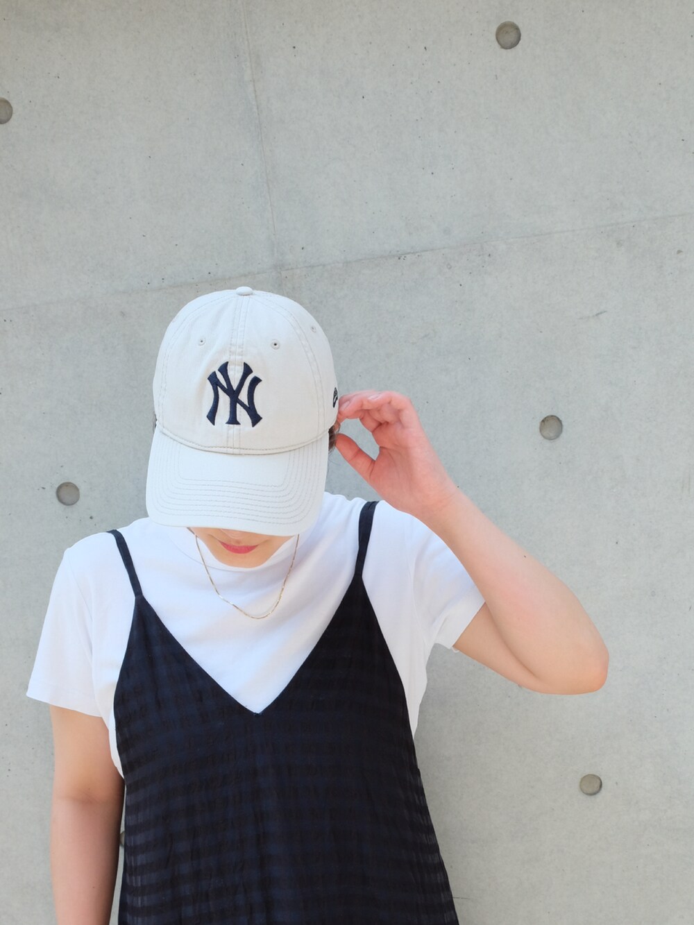 ブラック系のワンピース、ブラック系のサンダル、ホワイト系のTシャツ/カットソーを着用したレディースの夏コーディネートの3枚目の写真