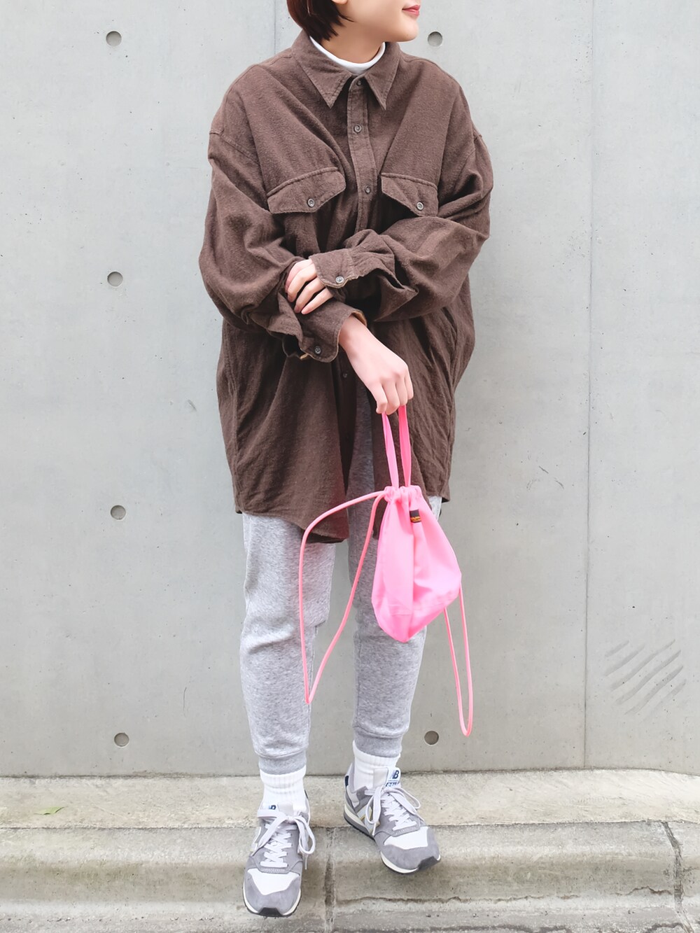 ホワイト系のTシャツ/カットソー、ピンク系のバッグ、グレー系のスニーカーを着用したレディースの冬コーディネートの2枚目の写真