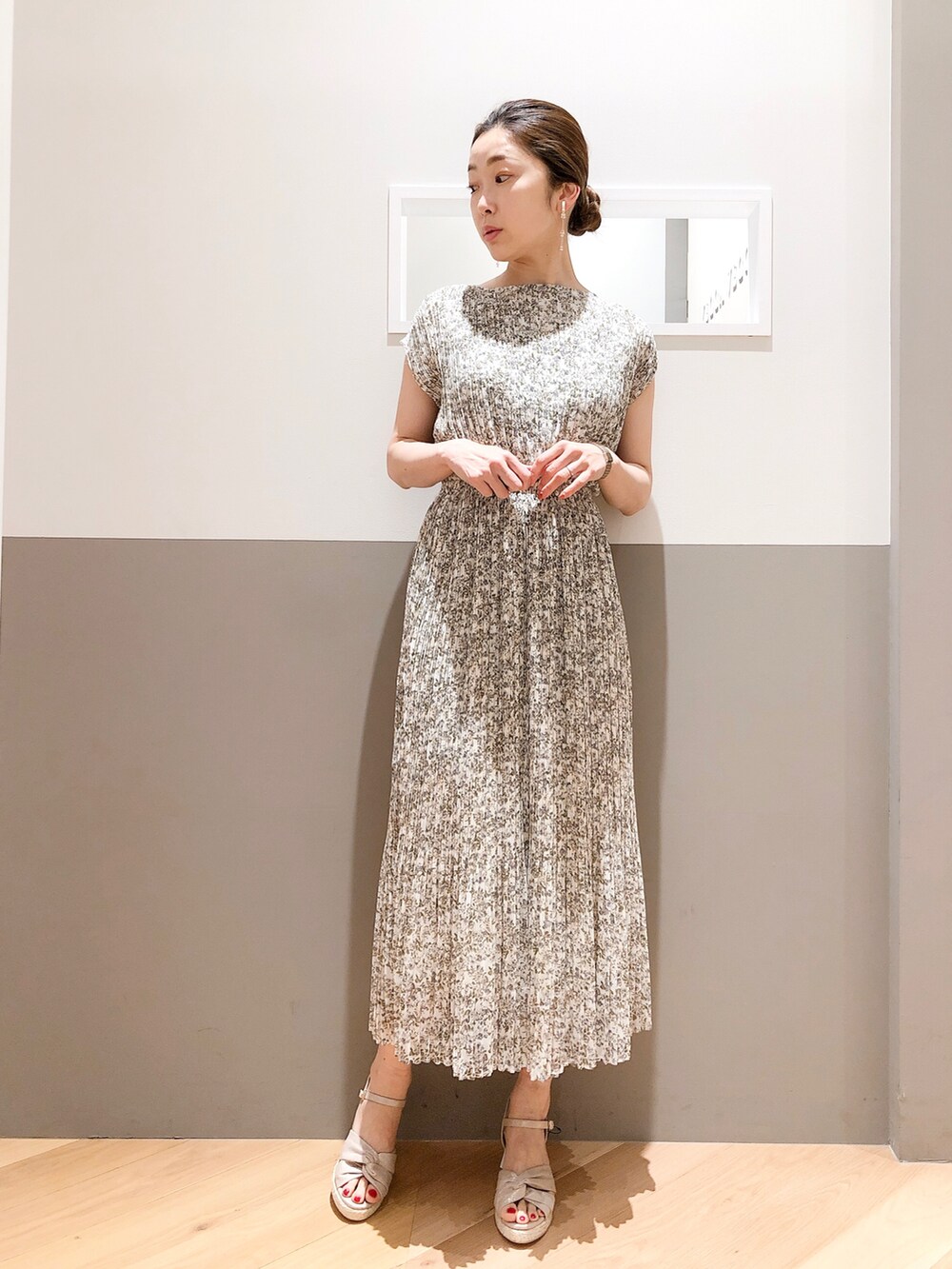 ホワイト系のワンピース、ピンク系のカーディガン/ボレロ、ゴールド系のイヤリングを着用したレディースの春コーディネートの2枚目の写真