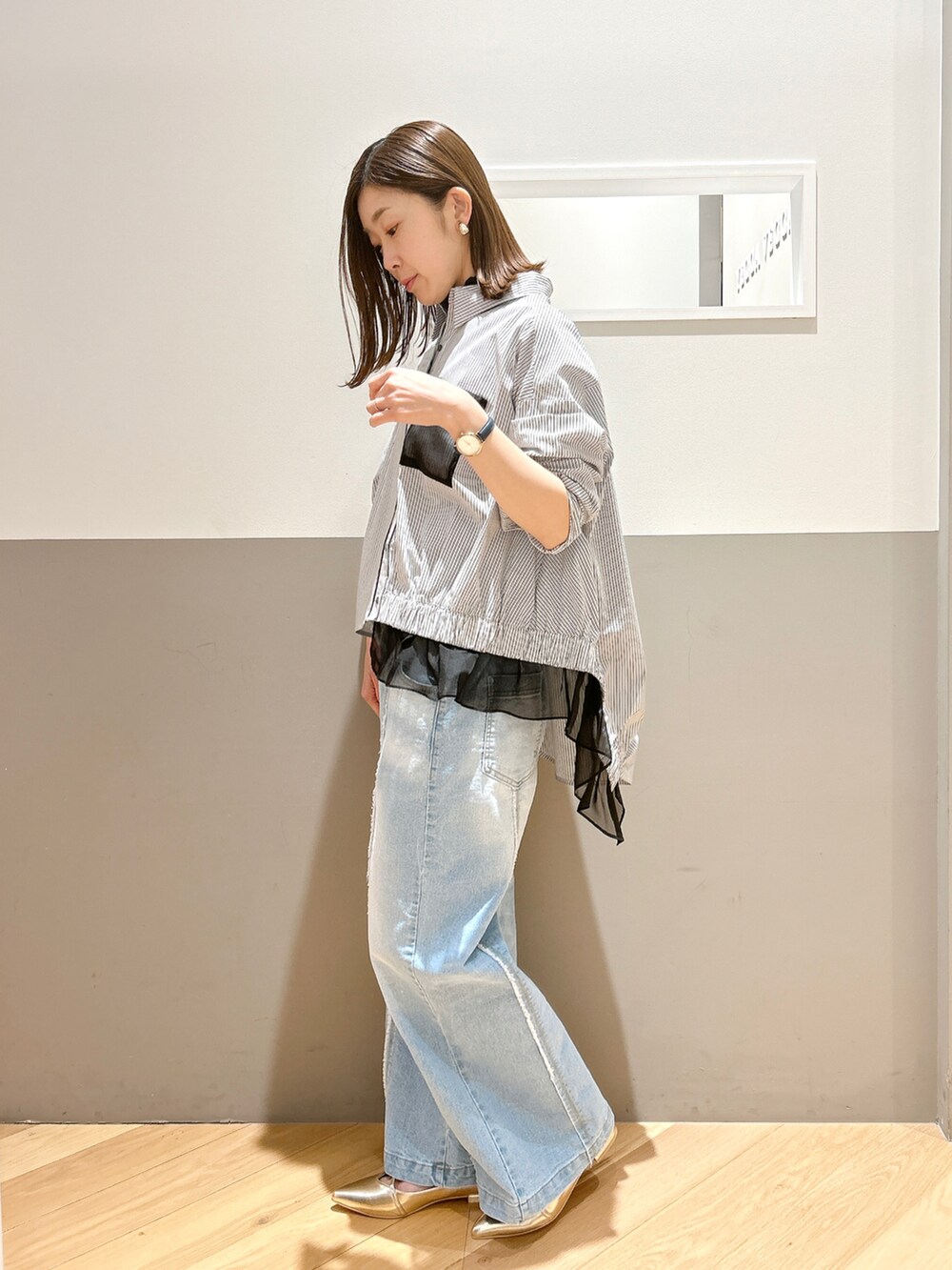 ブラック系のシャツ/ブラウス、ブラック系のTシャツ/カットソー、ブルー系のデニムパンツを着用したレディースの春コーディネートの2枚目の写真