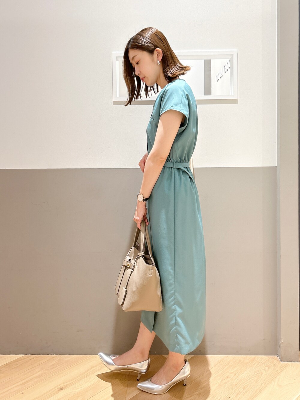 グリーン系のワンピース、ホワイト系のカーディガン/ボレロ、シルバー系のパンプスを着用したレディースの夏コーディネートの3枚目の写真
