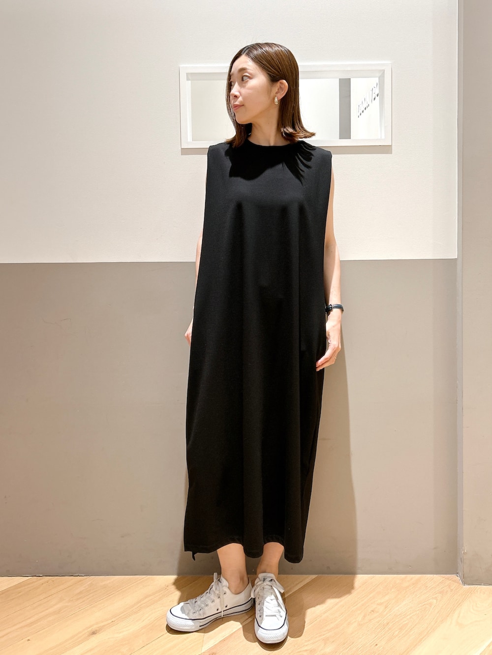 ブラウン系のテーラードジャケット、ブラック系のワンピース、ホワイト系のスニーカーを着用したレディースの夏コーディネートの2枚目の写真