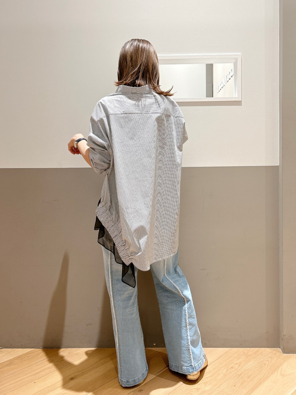 ブラック系のシャツ/ブラウス、ブラック系のTシャツ/カットソー、ブルー系のデニムパンツを着用したレディースの春コーディネートの3枚目の写真