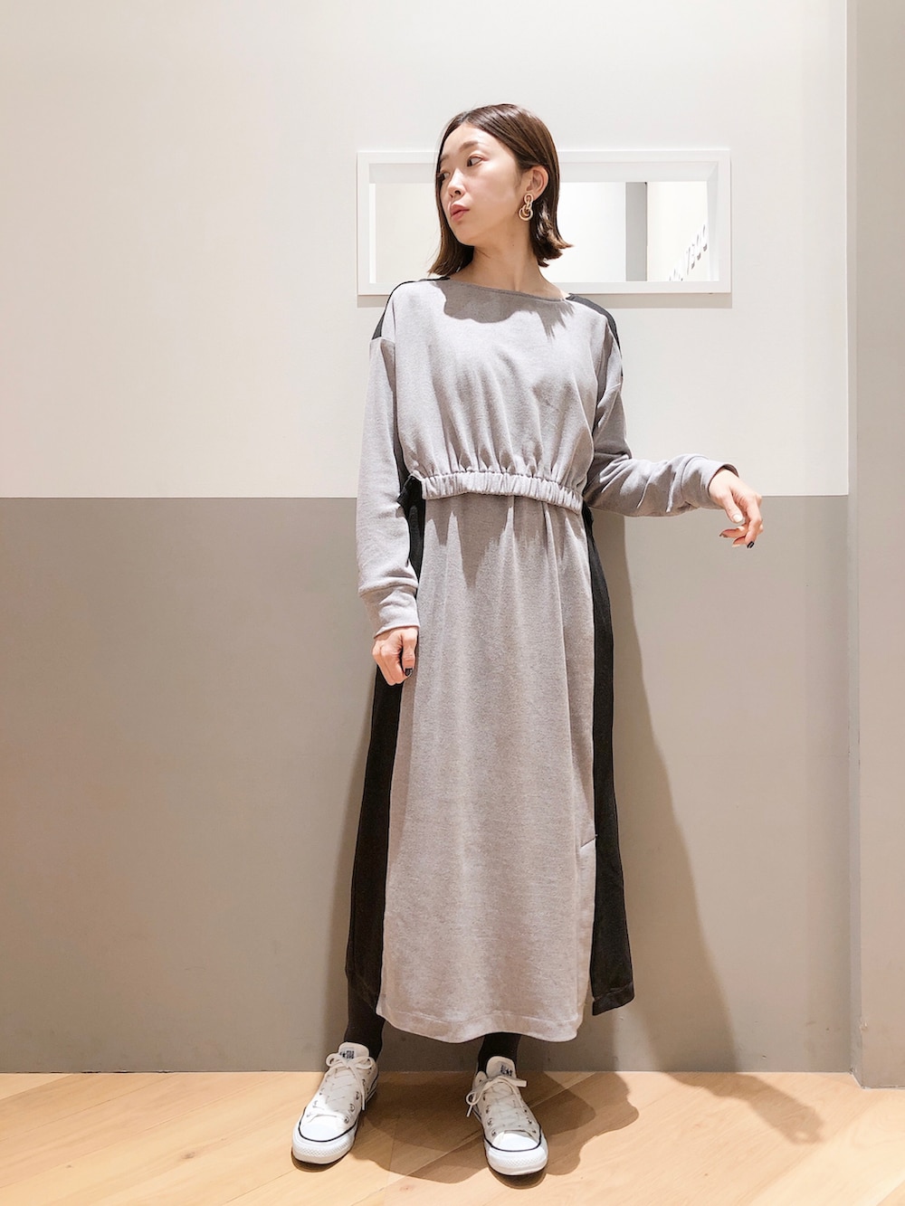 ブルー系のチェスターコート、グレー系のワンピース、ホワイト系のスニーカーを着用したレディースの冬コーディネートの2枚目の写真