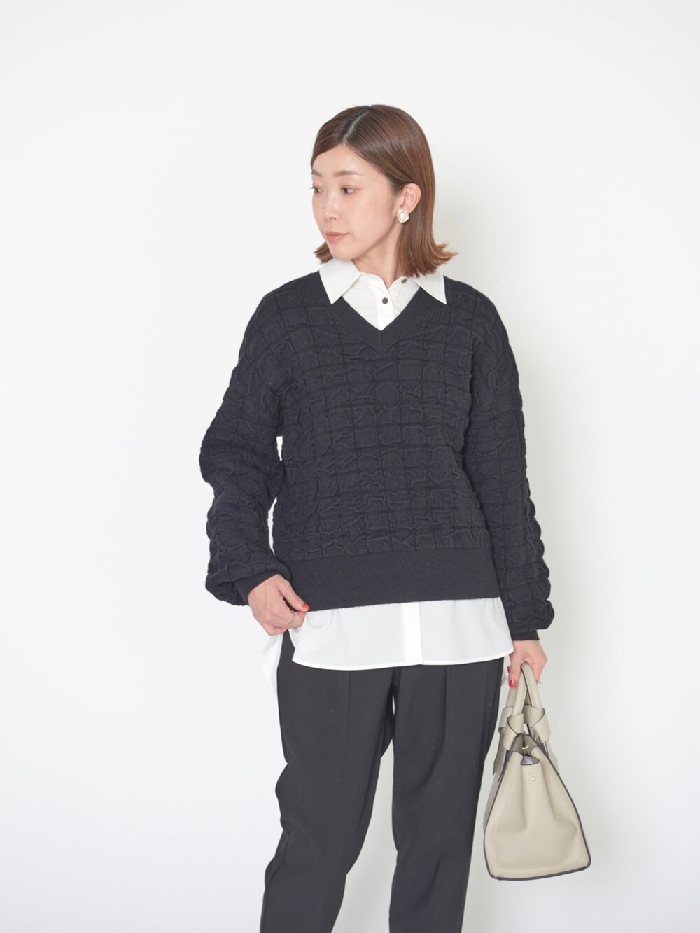 ホワイト系のニット/セーター、ホワイト系のシャツ/ブラウス、ブラック系のその他パンツを着用したレディースの冬コーディネートの2枚目の写真