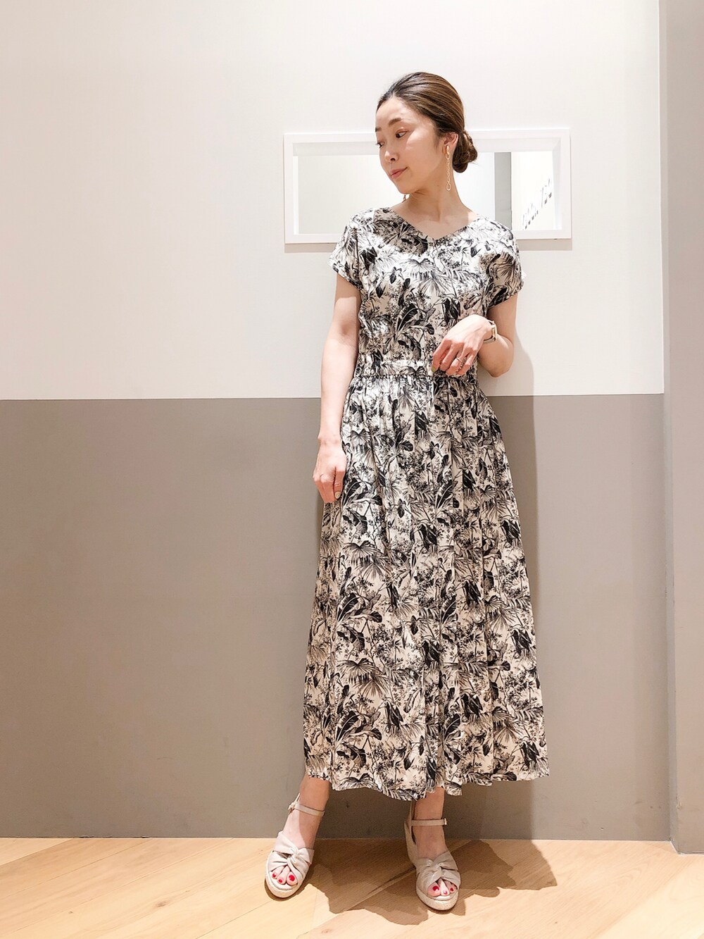 ブラック系のワンピース、オレンジ系のカーディガン/ボレロ、シルバー系のイヤリングを着用したレディースの夏コーディネートの2枚目の写真