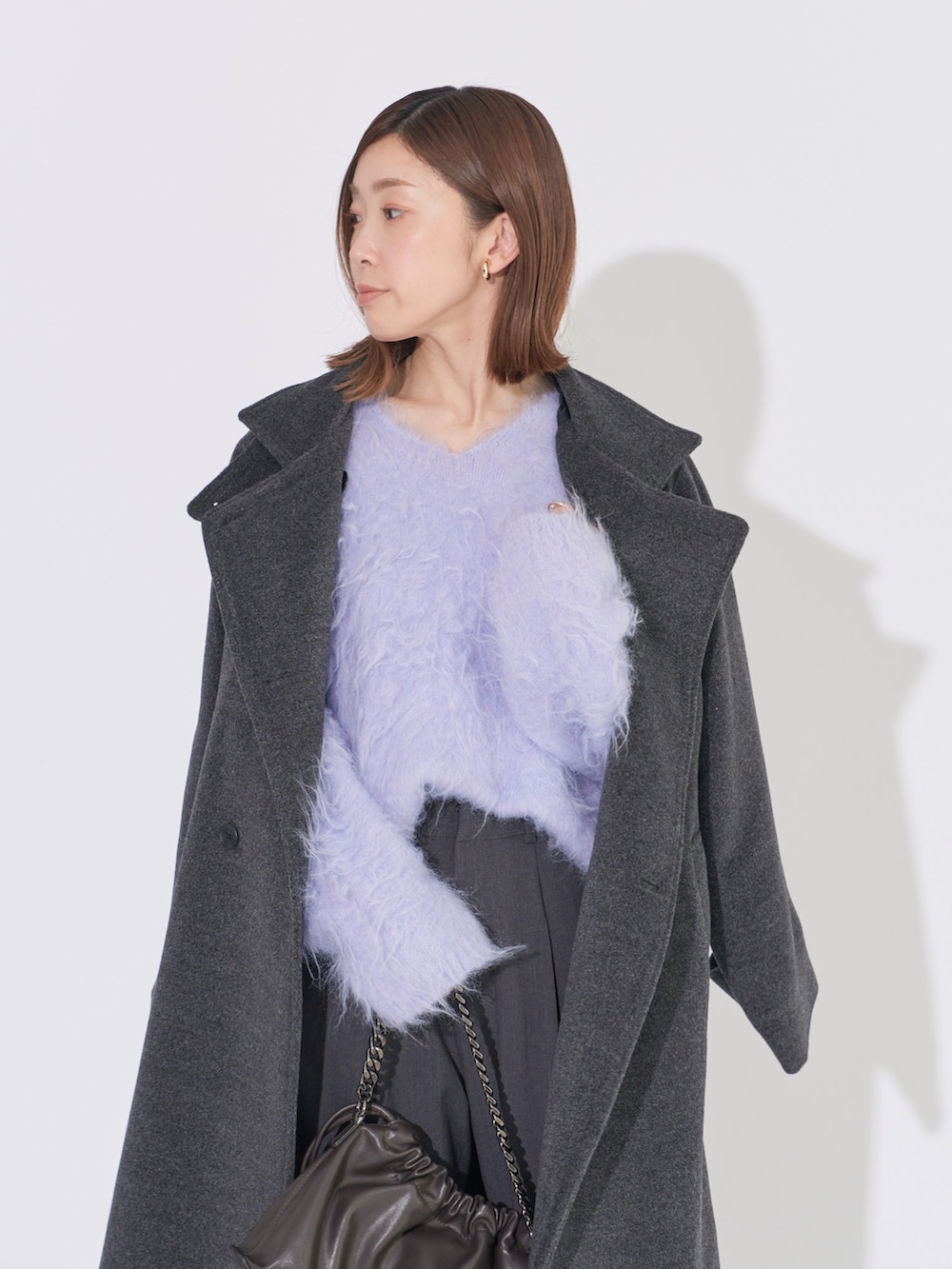 グレー系のその他アウター、パープル系のニット/セーター、グレー系のその他パンツを着用したレディースの冬コーディネートの3枚目の写真