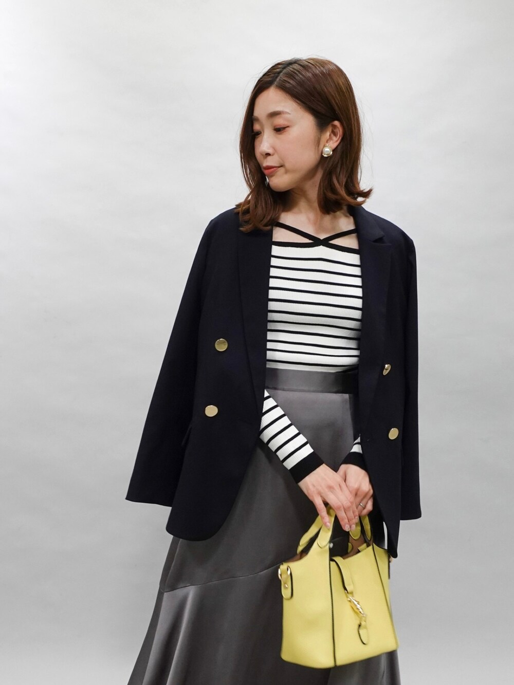 ブルー系のテーラードジャケット、その他のニット/セーター、グレー系のスカートを着用したレディースの春コーディネートの2枚目の写真