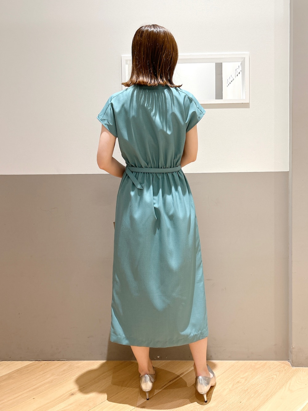 グリーン系のワンピース、ホワイト系のカーディガン/ボレロ、シルバー系のパンプスを着用したレディースの夏コーディネートの4枚目の写真