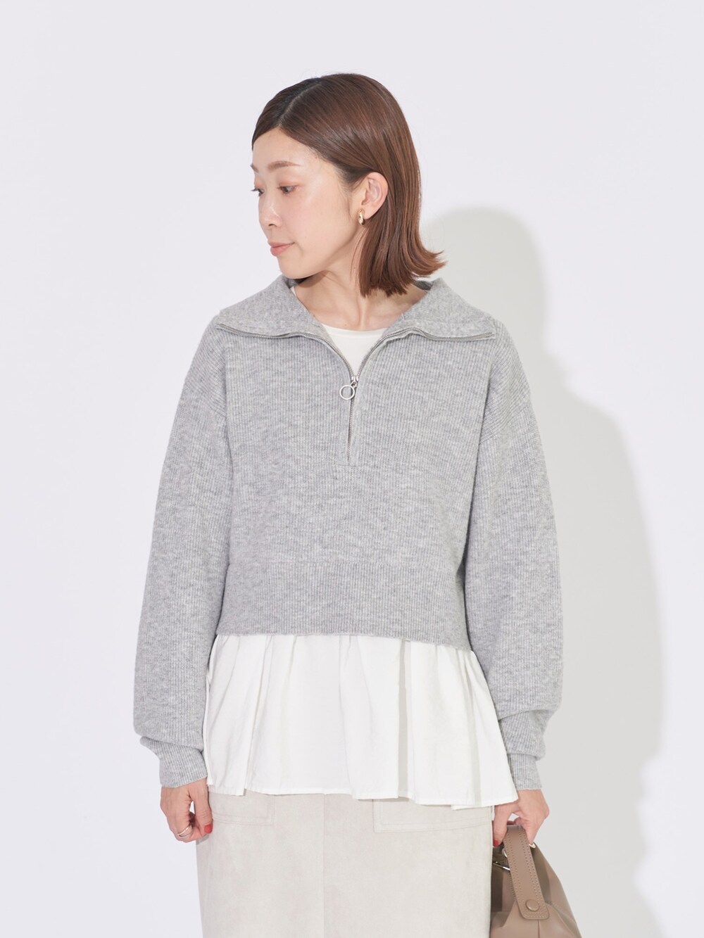 グレー系のニット/セーター、ベージュ系のスカートを着用したレディースの冬コーディネートの3枚目の写真