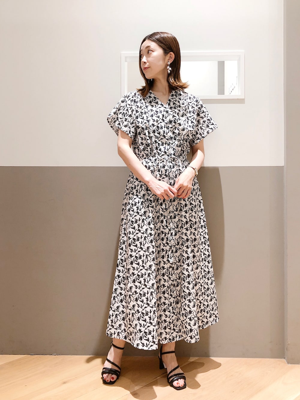 ブラック系のワンピース、パープル系のカーディガン/ボレロ、ブラック系のサンダルを着用したレディースの夏コーディネートの2枚目の写真