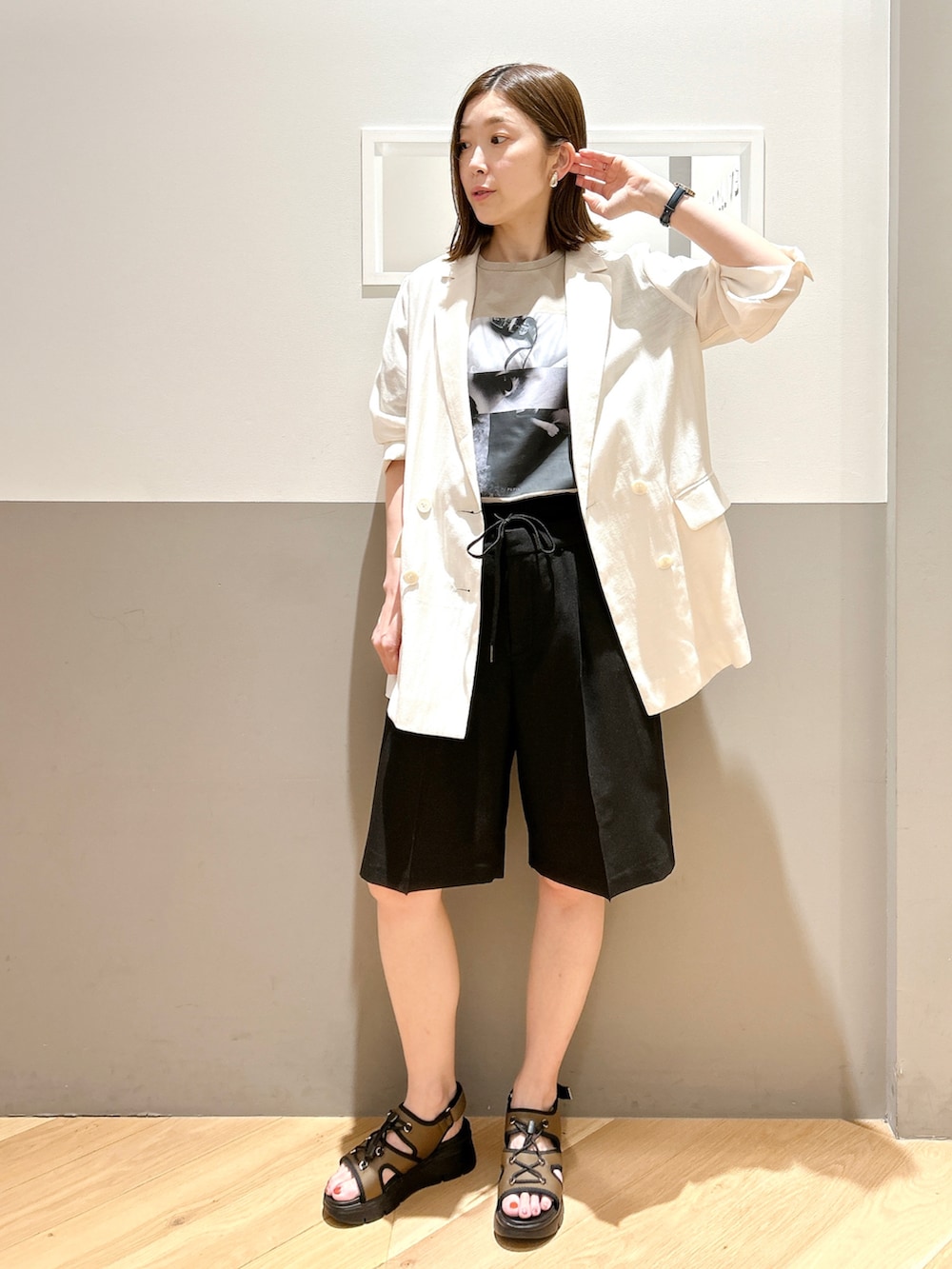 ホワイト系のテーラードジャケット、ベージュ系のTシャツ/カットソー、ブラック系のその他パンツを着用したレディースの夏コーディネートの2枚目の写真