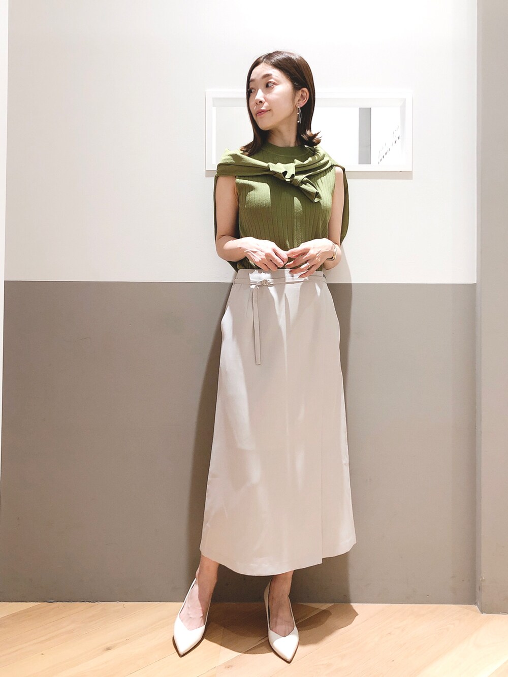 グリーン系のカーディガン/ボレロ、グリーン系のニット/セーター、ベージュ系のスカートを着用したレディースの夏コーディネートの2枚目の写真