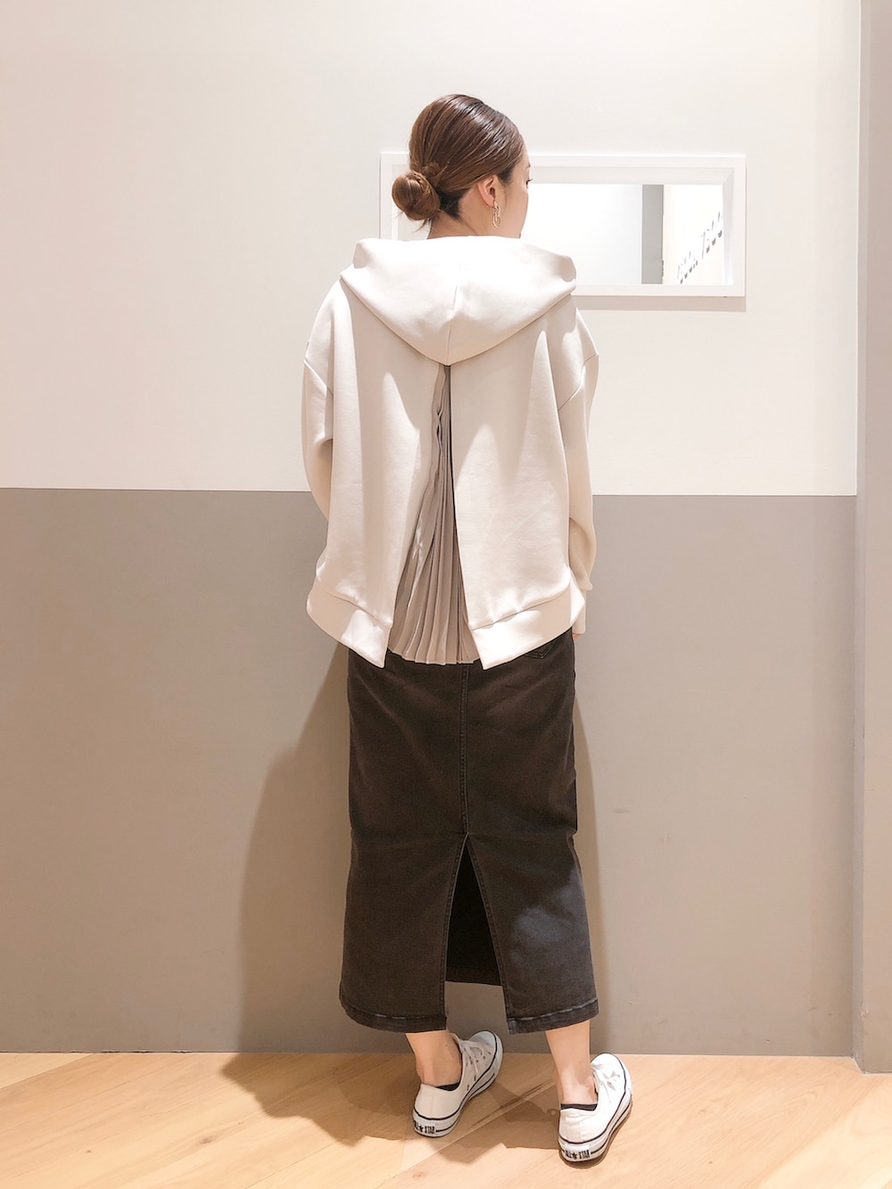 ベージュ系のパーカー、ホワイト系のニット/セーター、ブラック系のスカートを着用したレディースの秋コーディネートの2枚目の写真