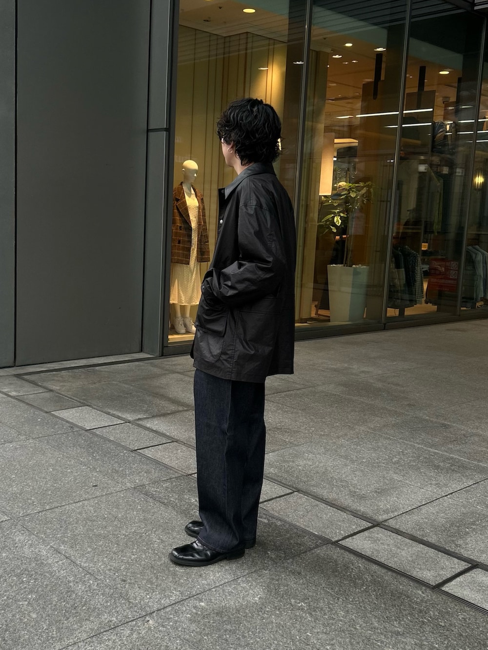 ブラック系のその他アウター、レッド系のニット/セーター、ブルー系のデニムパンツを着用したメンズの冬コーディネートの3枚目の写真