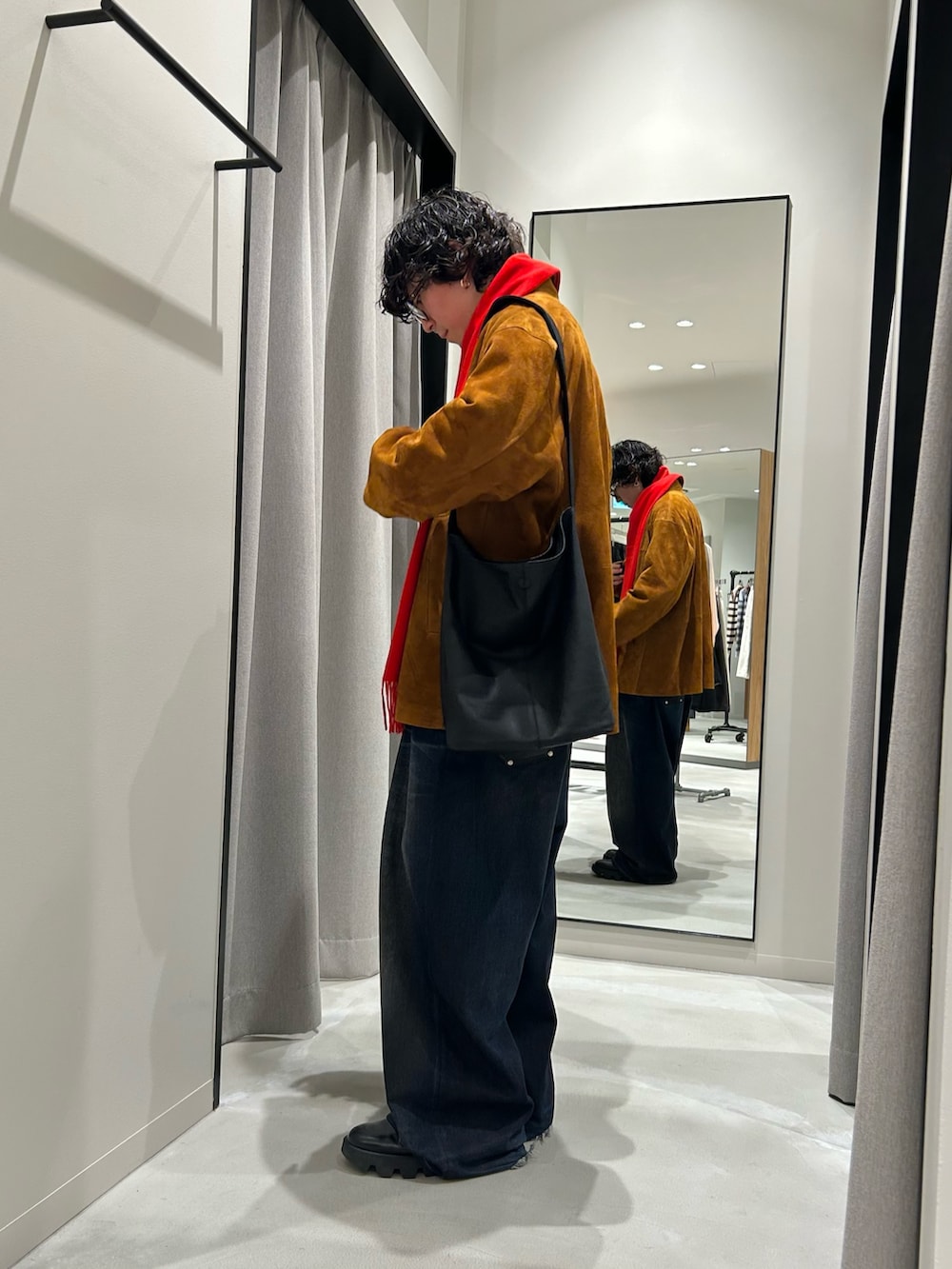 ブラウン系のその他アウター、レッド系のマフラーを着用したメンズの冬コーディネートの2枚目の写真