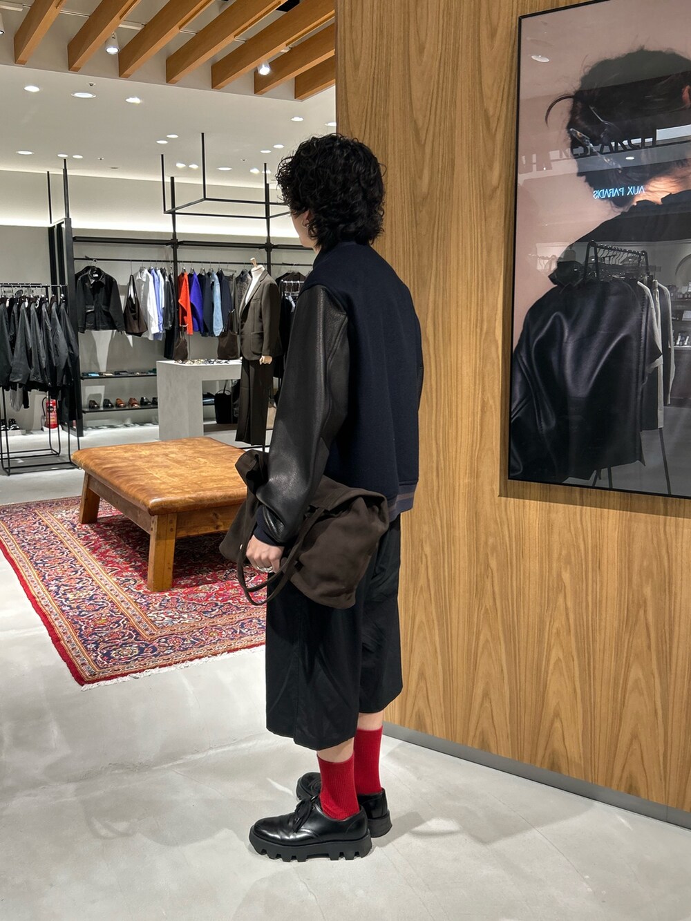 ブルー系のスタジャン、ブラウン系のトートバッグを着用したメンズの秋コーディネートの2枚目の写真