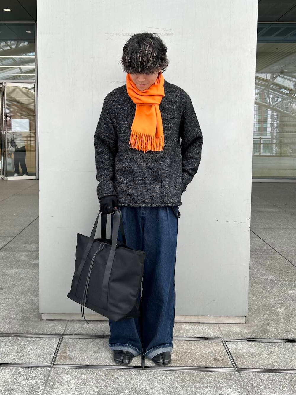 ブラック系のニット/セーター、ブラック系のトートバッグ、ブラック系の手袋を着用したメンズの秋コーディネートの2枚目の写真