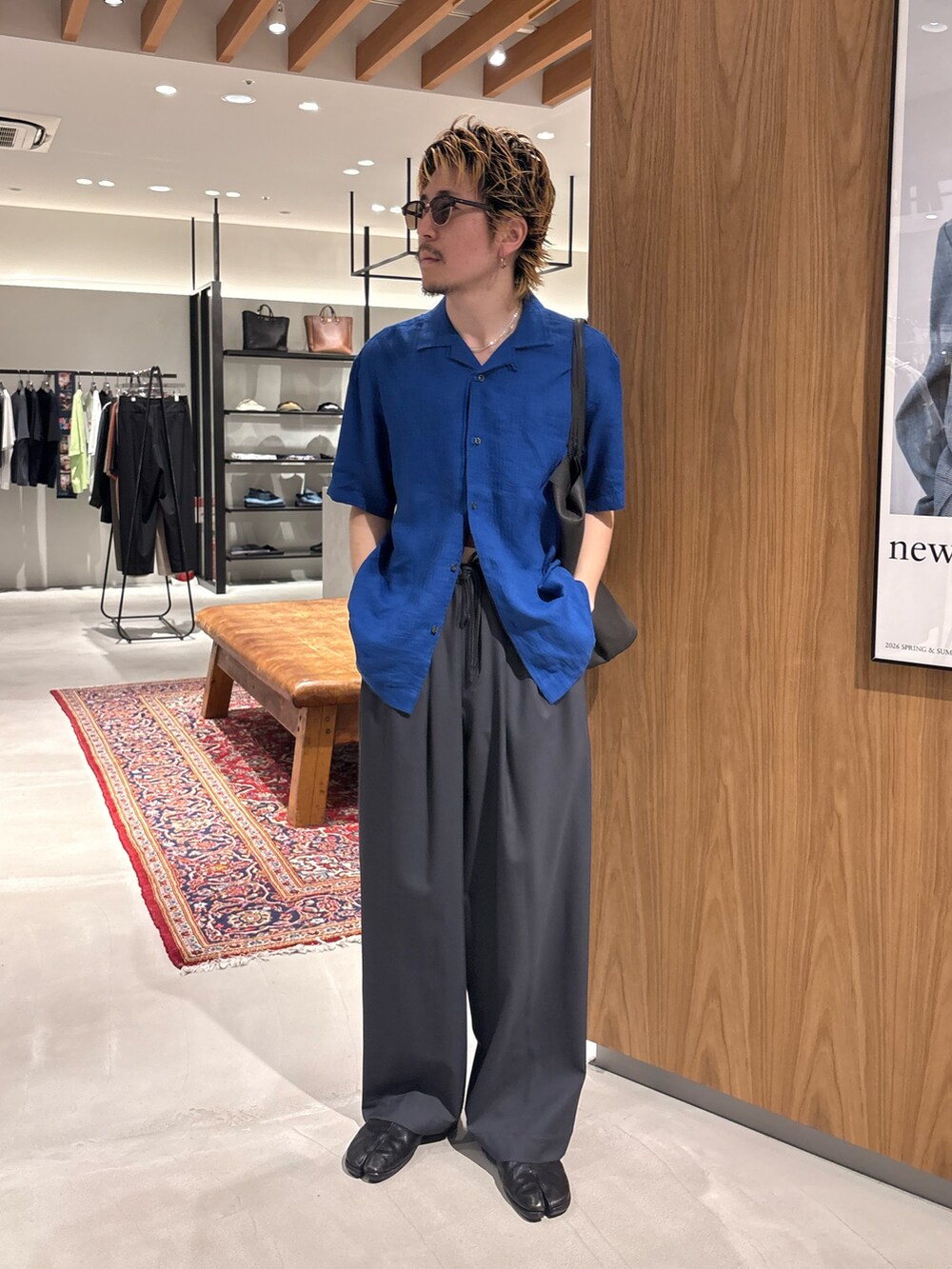 ブルー系のシャツ/ブラウス、グレー系のその他パンツ、ブラック系のメガネを着用したメンズの夏コーディネートの2枚目の写真