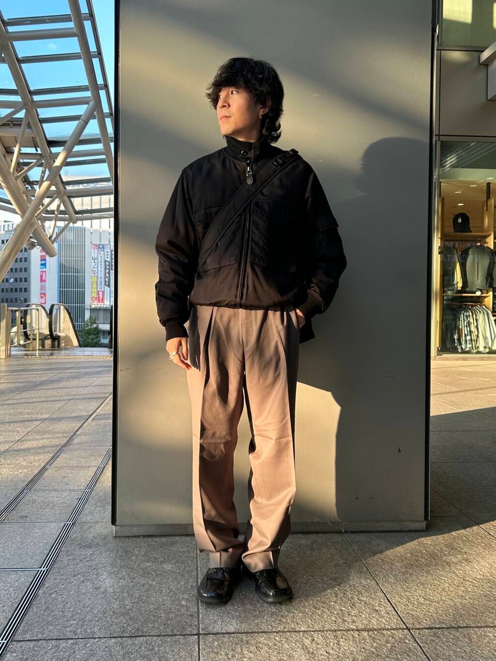 ブラック系のトートバッグ、ベージュ系のその他パンツ、ブラック系のその他アウターを着用したメンズの秋コーディネートの2枚目の写真