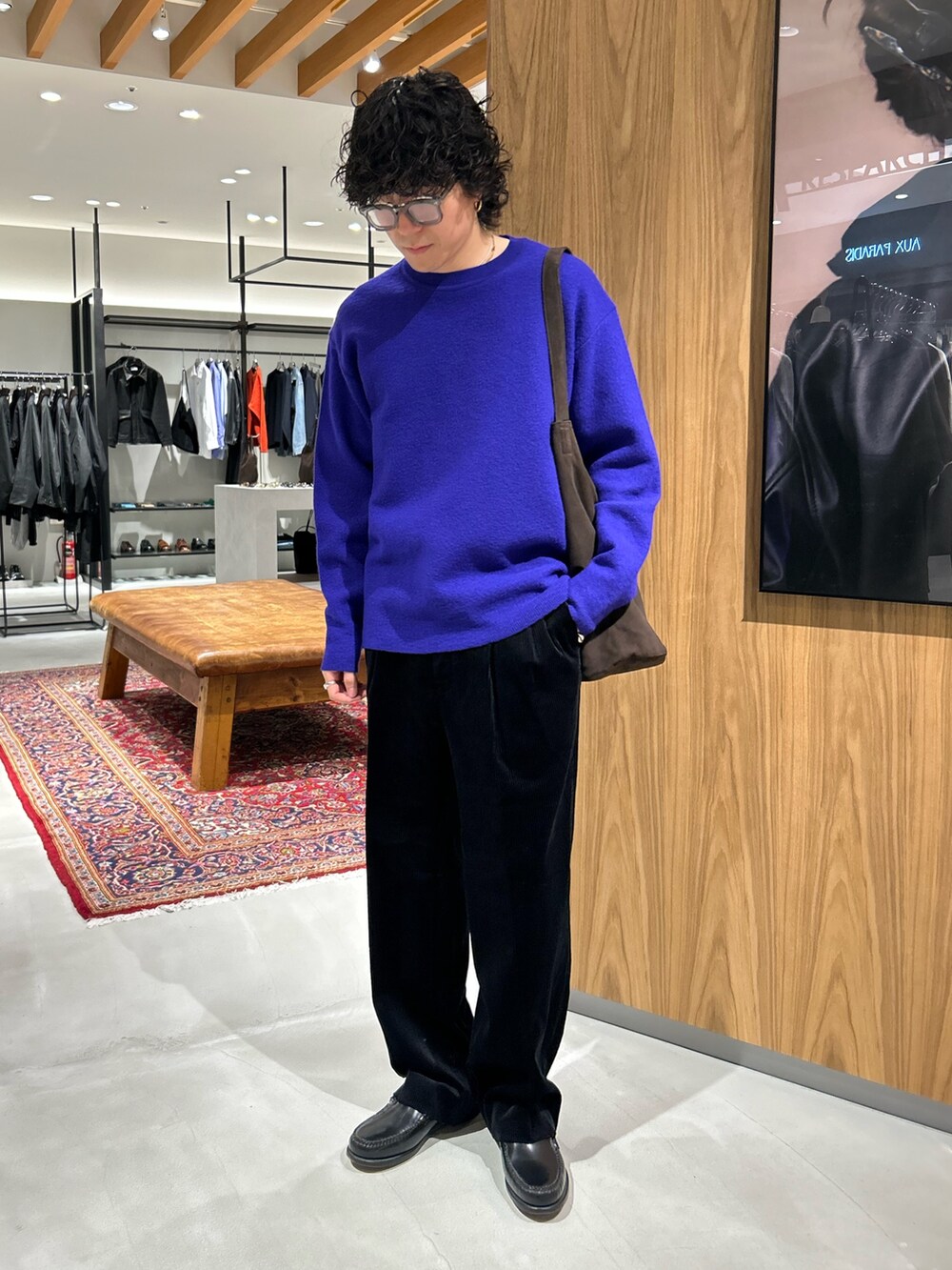 パープル系のニット/セーター、ブラック系のその他パンツ、ブラウン系のトートバッグを着用したメンズの秋コーディネートの3枚目の写真