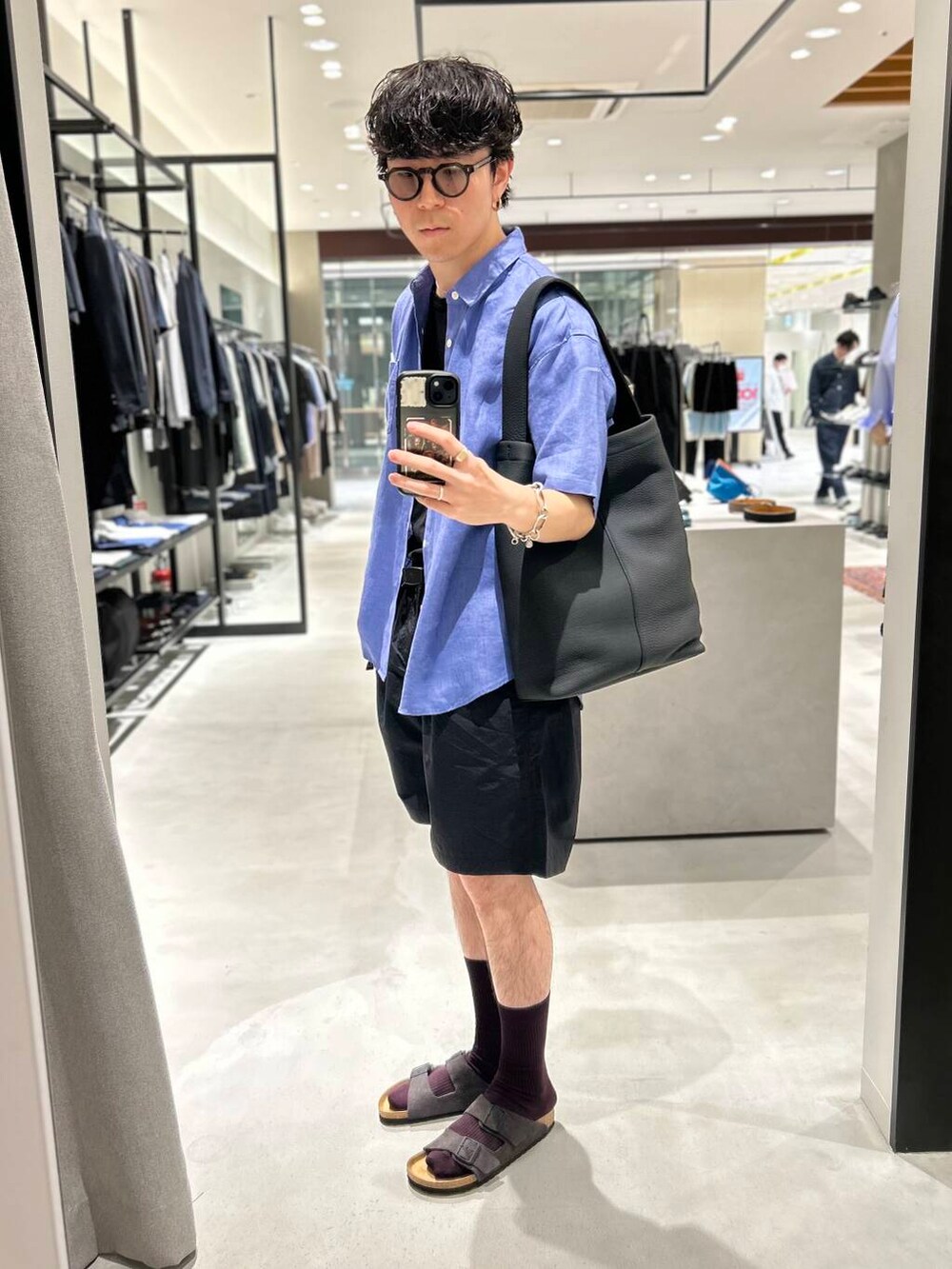 ブラック系のその他パンツ、グレー系のサンダル、ブラック系のトートバッグを着用したメンズの春コーディネートの2枚目の写真
