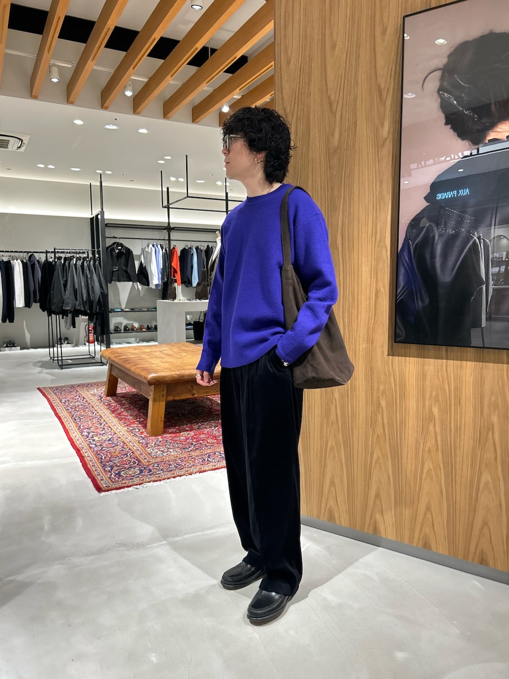 パープル系のニット/セーター、ブラック系のその他パンツ、ブラウン系のトートバッグを着用したメンズの秋コーディネートの2枚目の写真