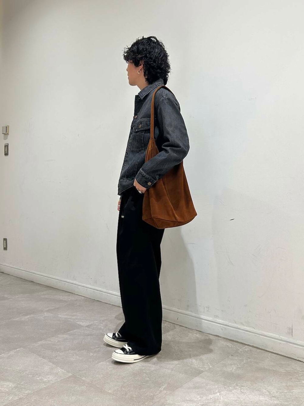 ブラウン系のトートバッグ、ブラック系のデニムジャケット、ブラック系のその他パンツを着用したメンズの夏コーディネートの3枚目の写真