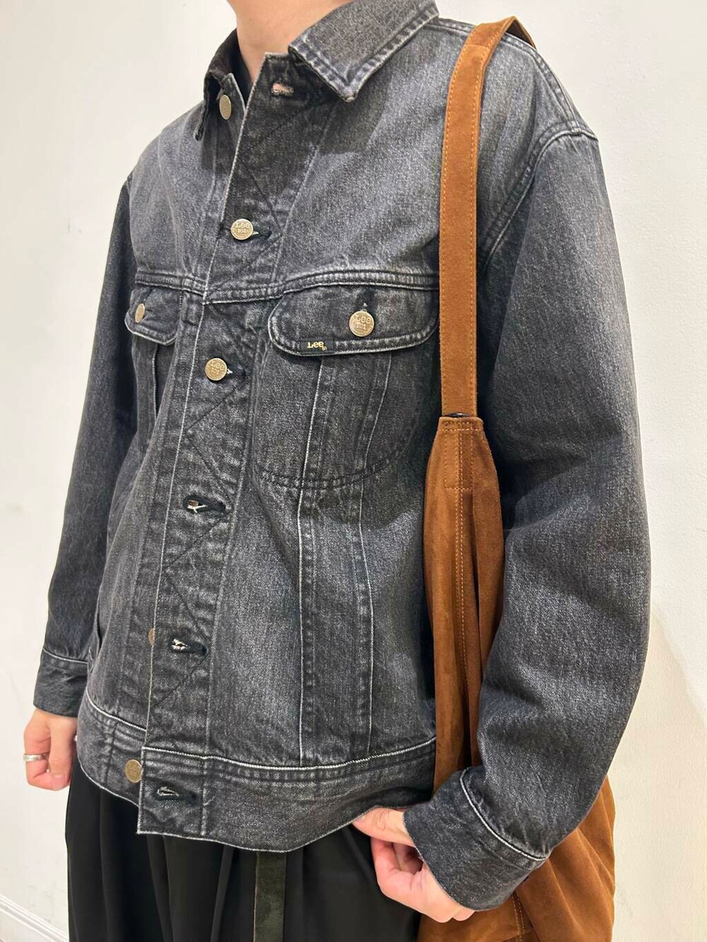 ブラウン系のトートバッグ、ブラック系のデニムジャケット、ブラック系のその他パンツを着用したメンズの夏コーディネートの4枚目の写真